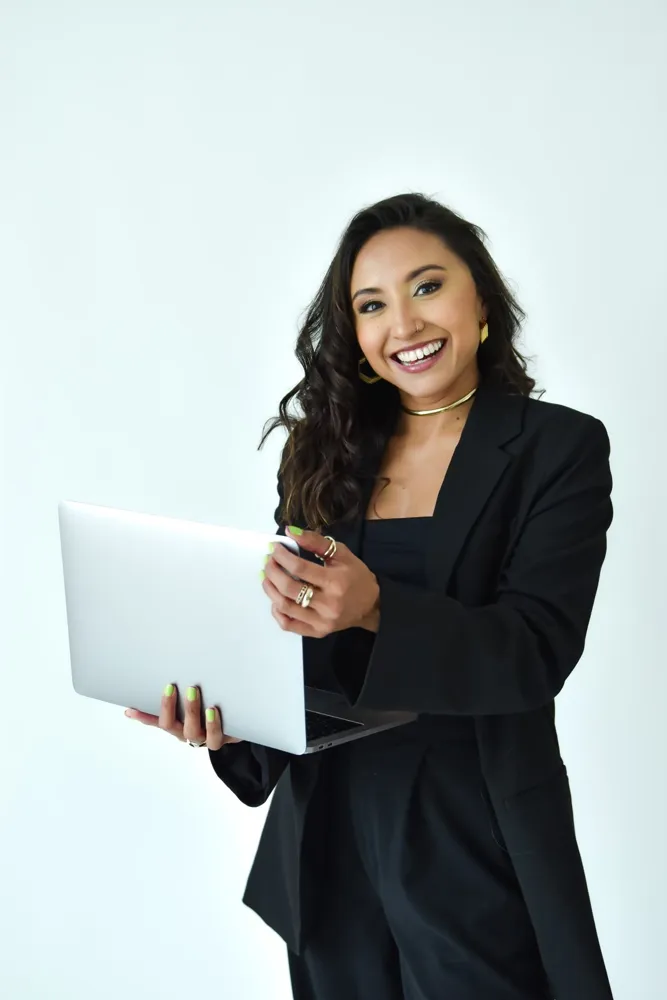 Ogui Magaña, fundadora de En Forma Seguros, con traje negro y laptop
